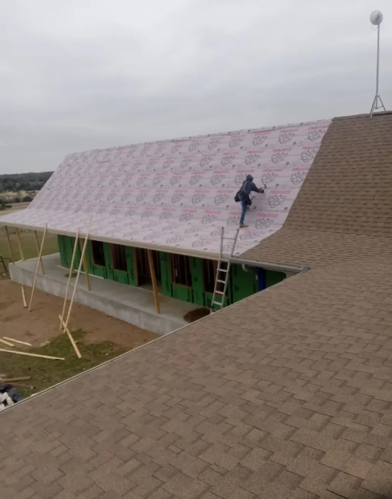 Worker preparing underlayment for a metal roof installation in Hagerstown